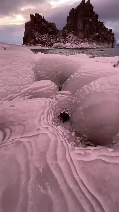 Лучи заката окрасили лёд Байкала в розовый